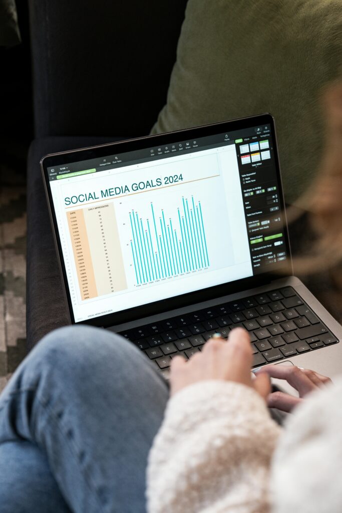 pexels-photo-19915765-19915765 Woman reviewing 2024 social media goals chart on laptop indoors.